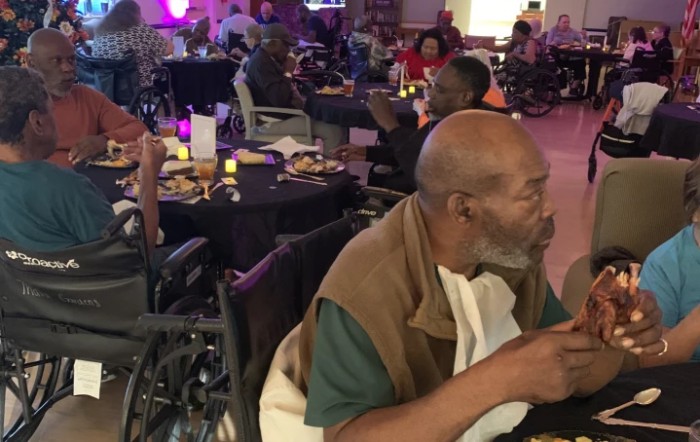 Elderly individuals enjoy a social dining event indoors.
