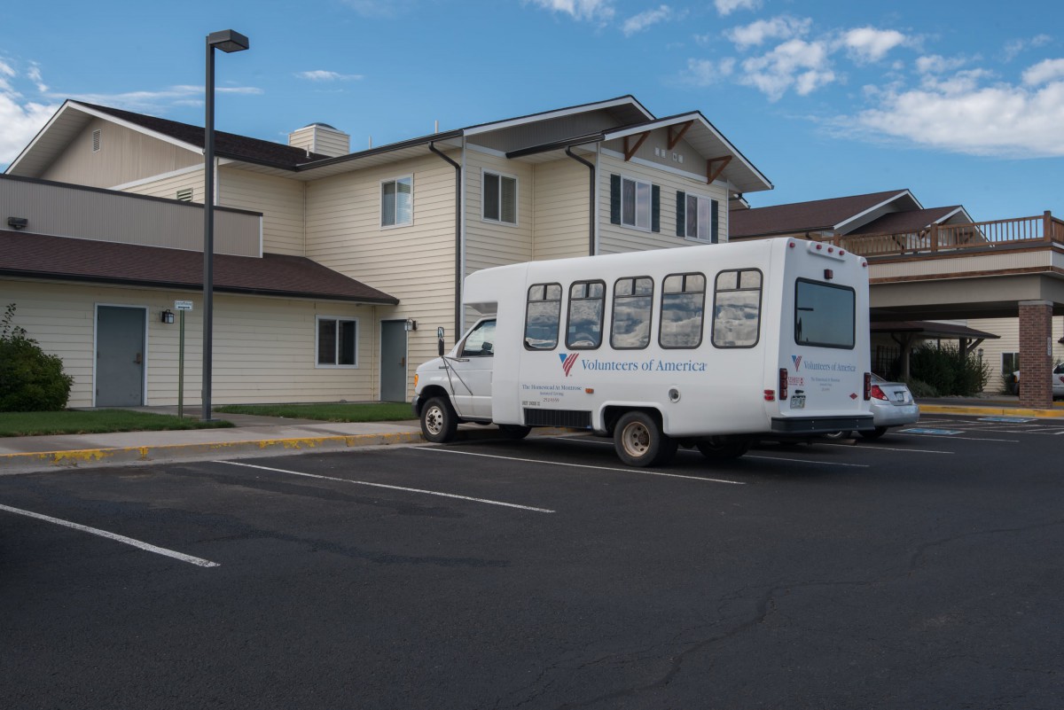 A bus parked in a residential parking lot on a clear day.