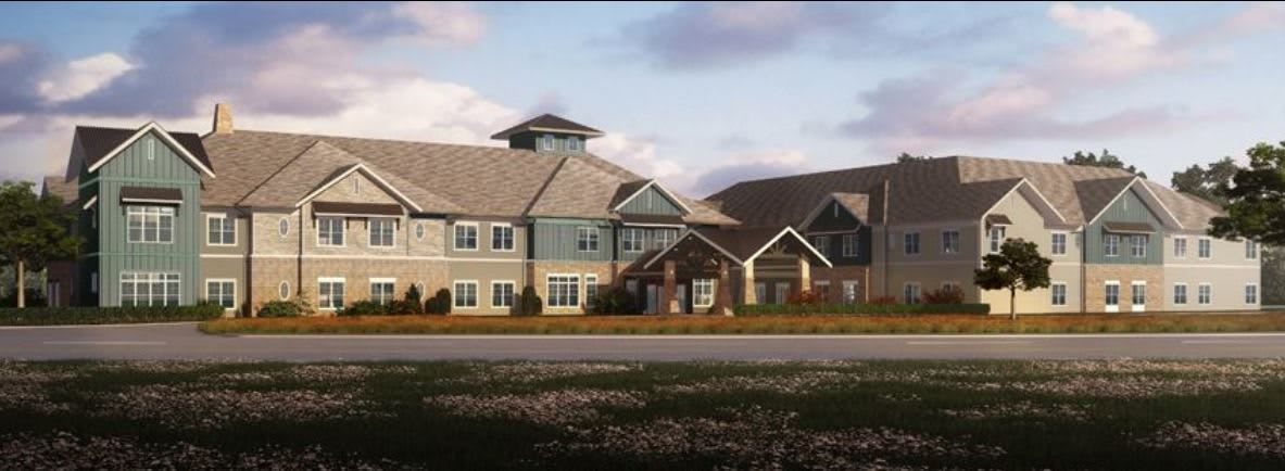 A modern residential building with a landscaped lawn in a suburban setting.