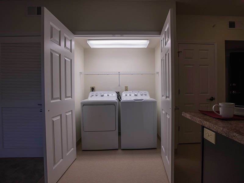 A compact laundry area with a washing machine and dryer inside a closet.