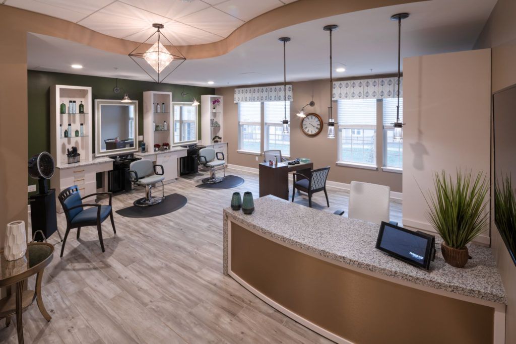 A modern salon interior with styling stations and a reception area.