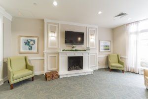 A cozy living room featuring a fireplace and TV with comfortable chairs.
