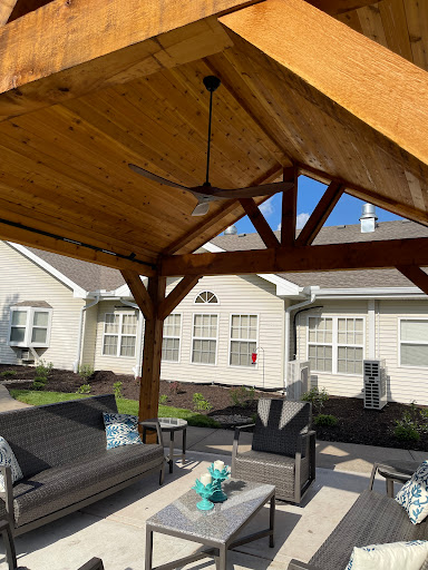 A cozy outdoor patio area under a wooden gazebo, perfect for relaxation and gatherings.