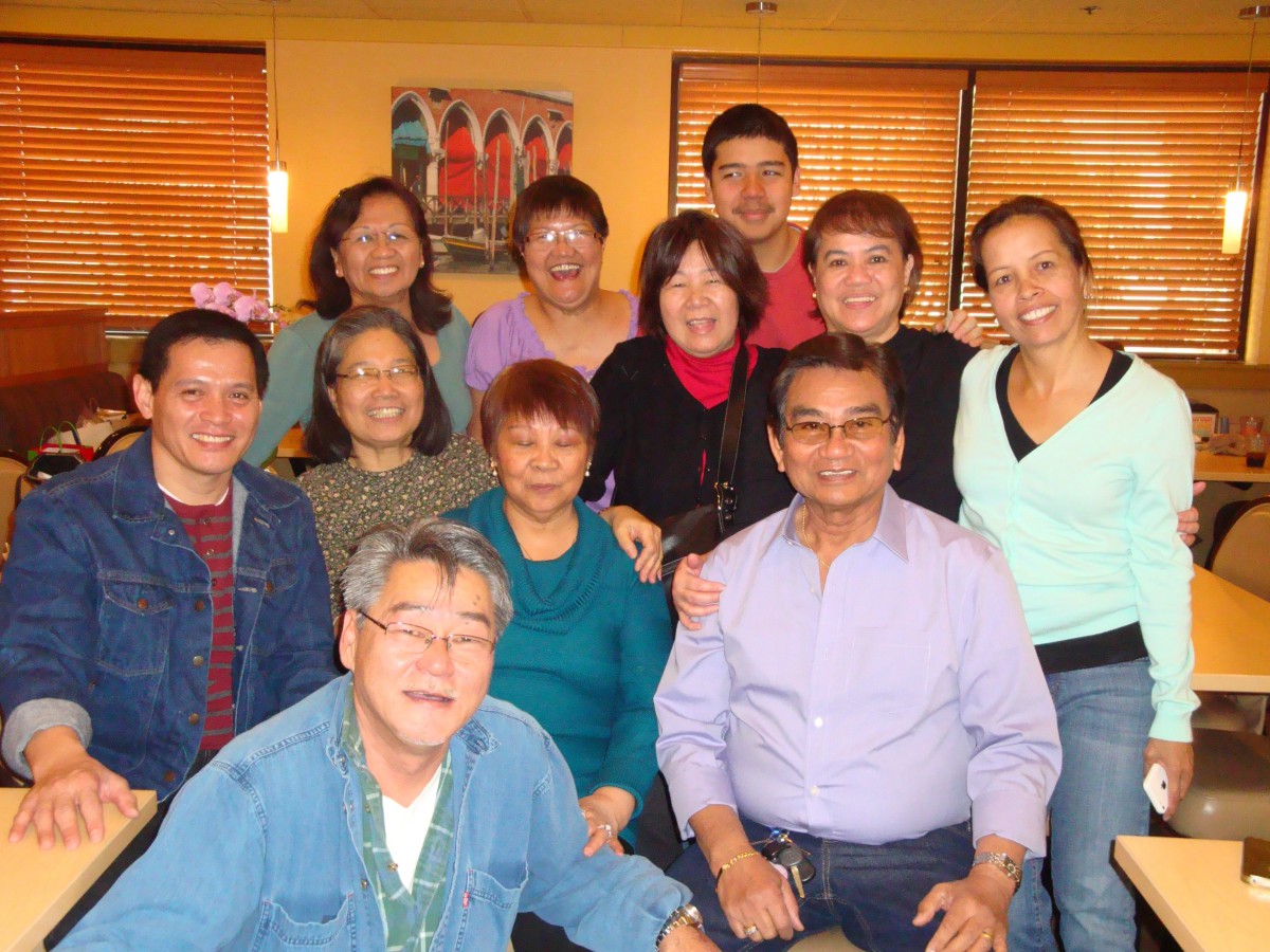 A group of smiling people posing together indoors.