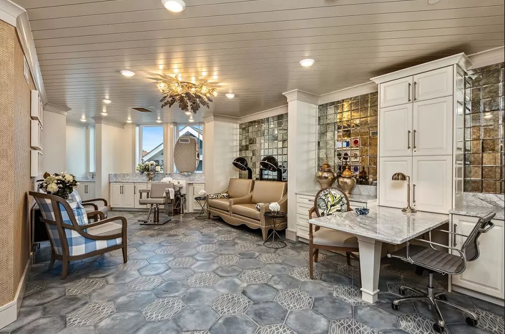 A luxurious living room featuring elegant furniture, a stylish chandelier, and beautiful marble flooring.