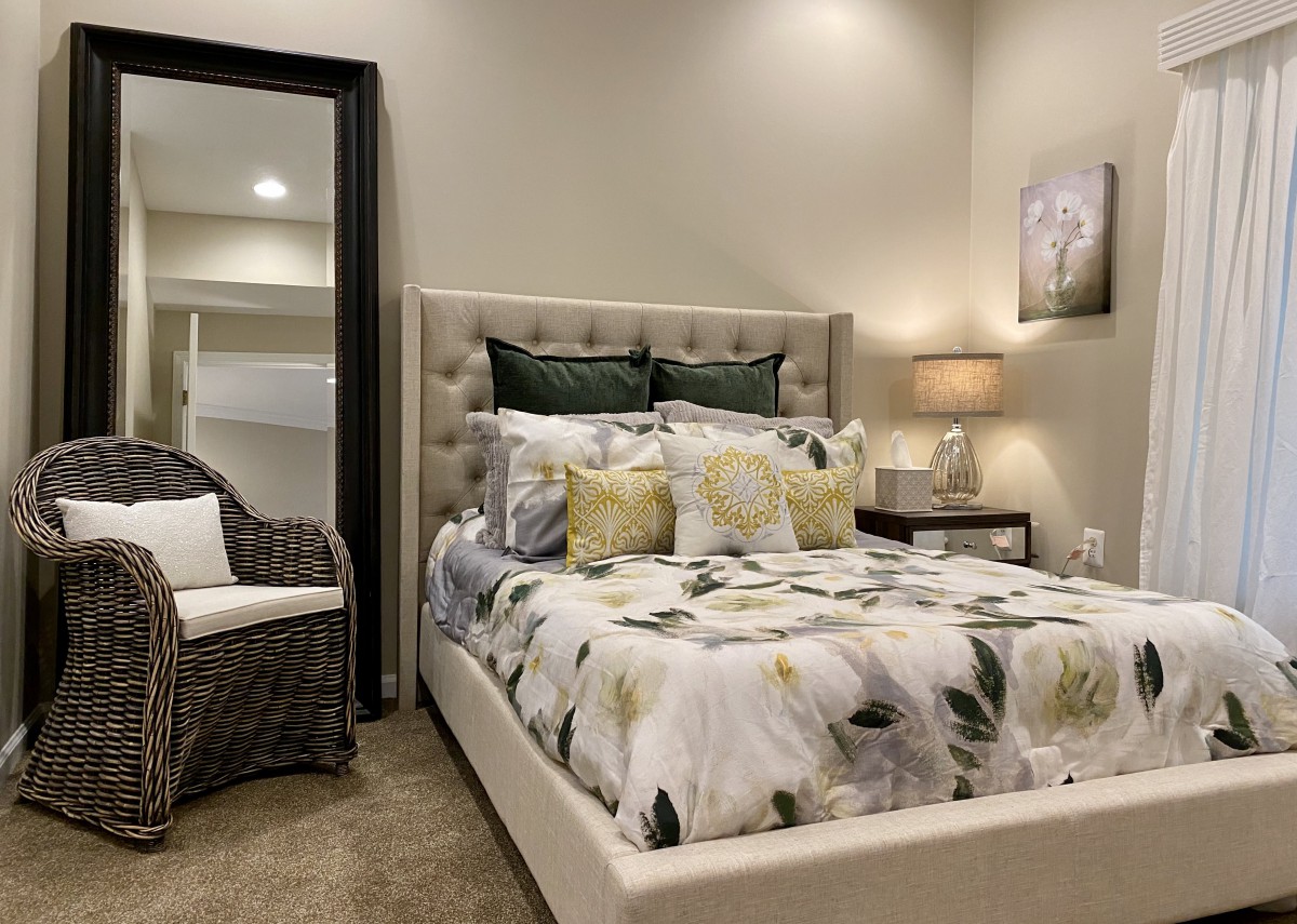 A cozy bedroom with a floral patterned bedspread, elegant decor, and soft lighting.