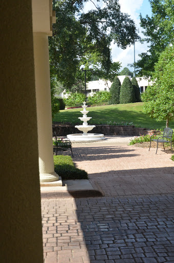 A serene garden pathway featuring a beautiful fountain and lush greenery.
