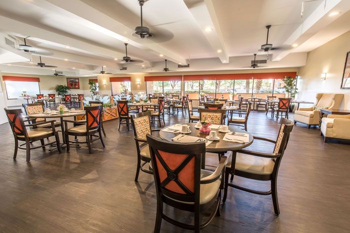 An elegantly set dining area in a spacious restaurant, showcasing neatly arranged tables and chairs.