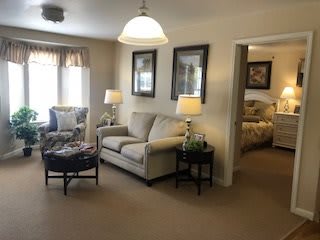 A cozy living room with a sofa, chairs, and decorative lamps.