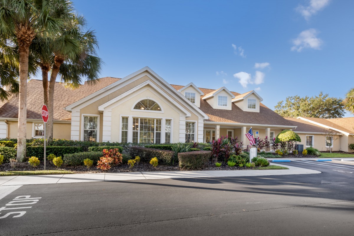 A suburban house with well-maintained landscaping and a clear blue sky.