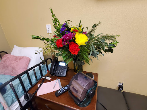 A vibrant floral arrangement enhances the bedside table in a hospital room.