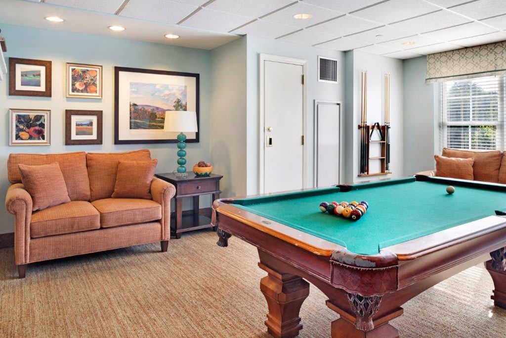 A cozy game room featuring a pool table and comfortable seating.