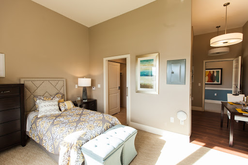 A cozy and stylish bedroom featuring a comfortable bed, decorative artwork, and soft lighting.