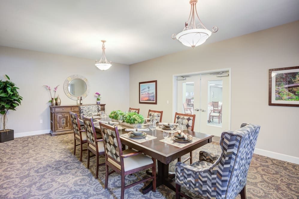 A spacious dining room with a large table, elegant chairs, and stylish decor.