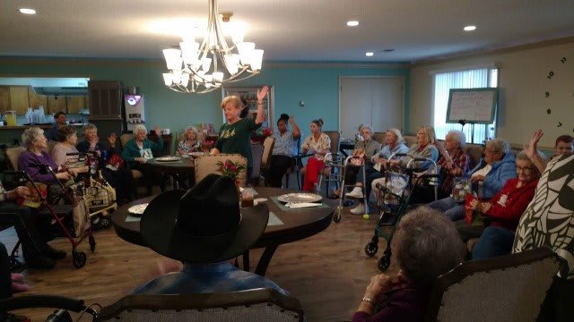 A community gathering of seniors in a cozy, well-lit room.