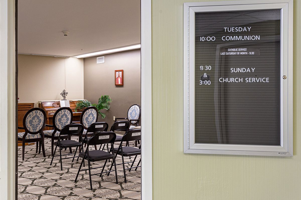 Empty meeting room with a schedule board outside.