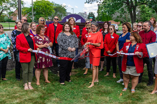 A momentous occasion as community members gather for a ribbon cutting ceremony, celebrating a new beginning.