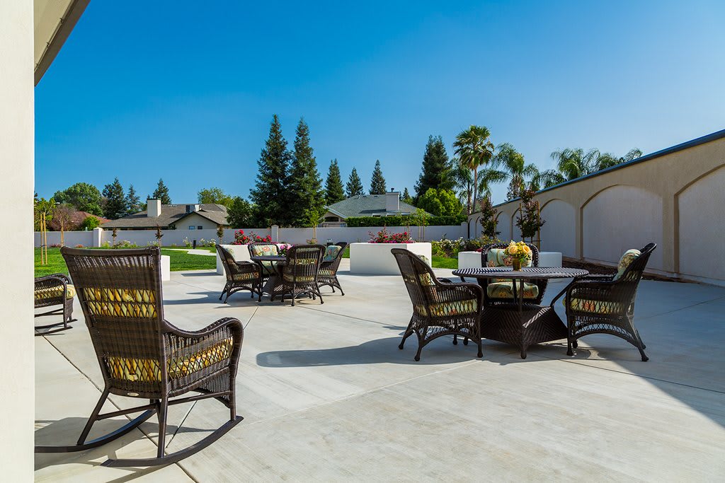 A spacious outdoor patio area with wicker furniture and a sunny landscape.