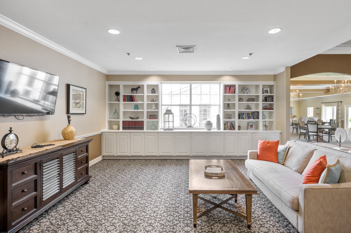 A cozy living room with bookshelves, a sofa, and a coffee table.
