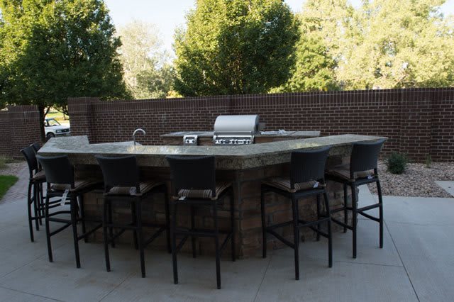 Outdoor patio with a barbecue grill and bar seating area.