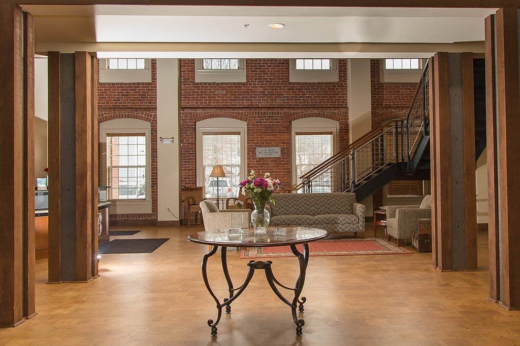 Cozy lobby with brick walls, featuring comfortable seating and a central table.