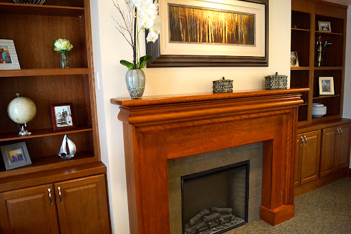 A beautifully designed living space featuring a wooden fireplace mantel, elegant artwork, and tasteful decorative accents.