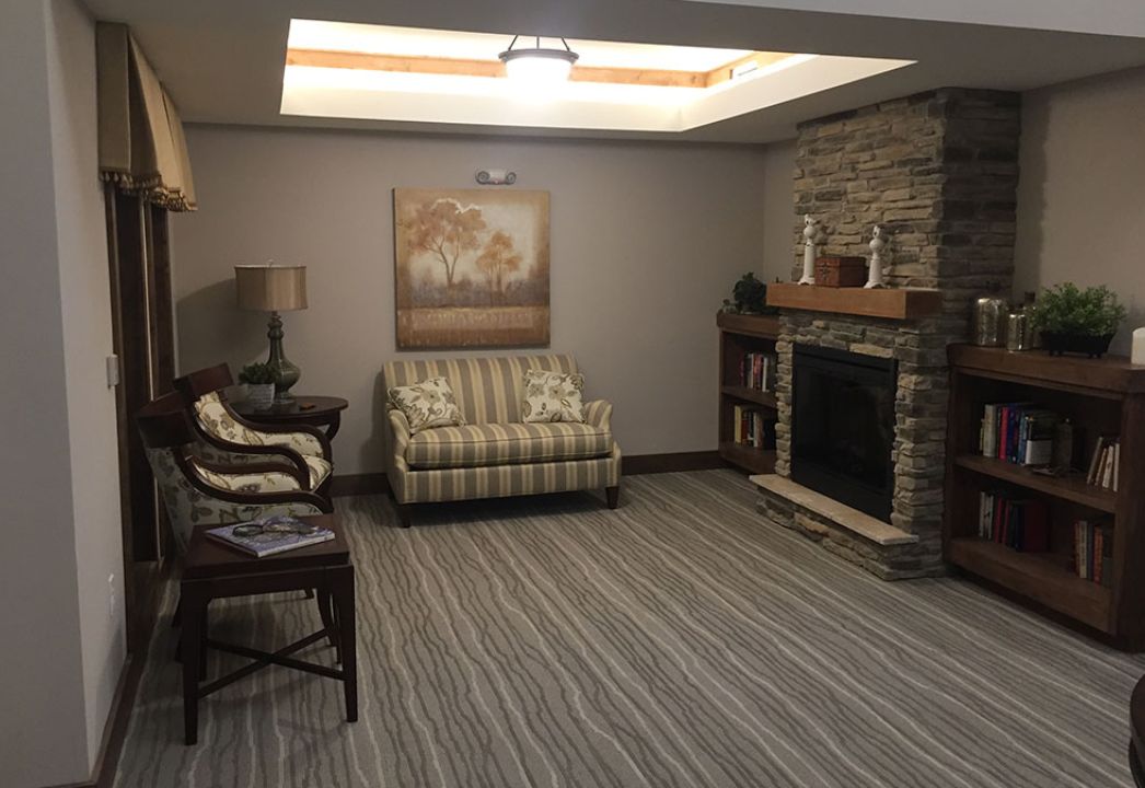 A cozy living room with a striped chair, fireplace, and decorative elements.