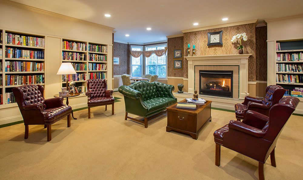 A cozy living room with a fireplace, bookshelves, and comfortable seating.
