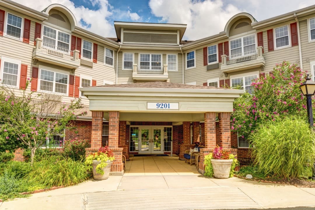 A residential building with a welcoming entrance, featuring a covered porch and landscaping.