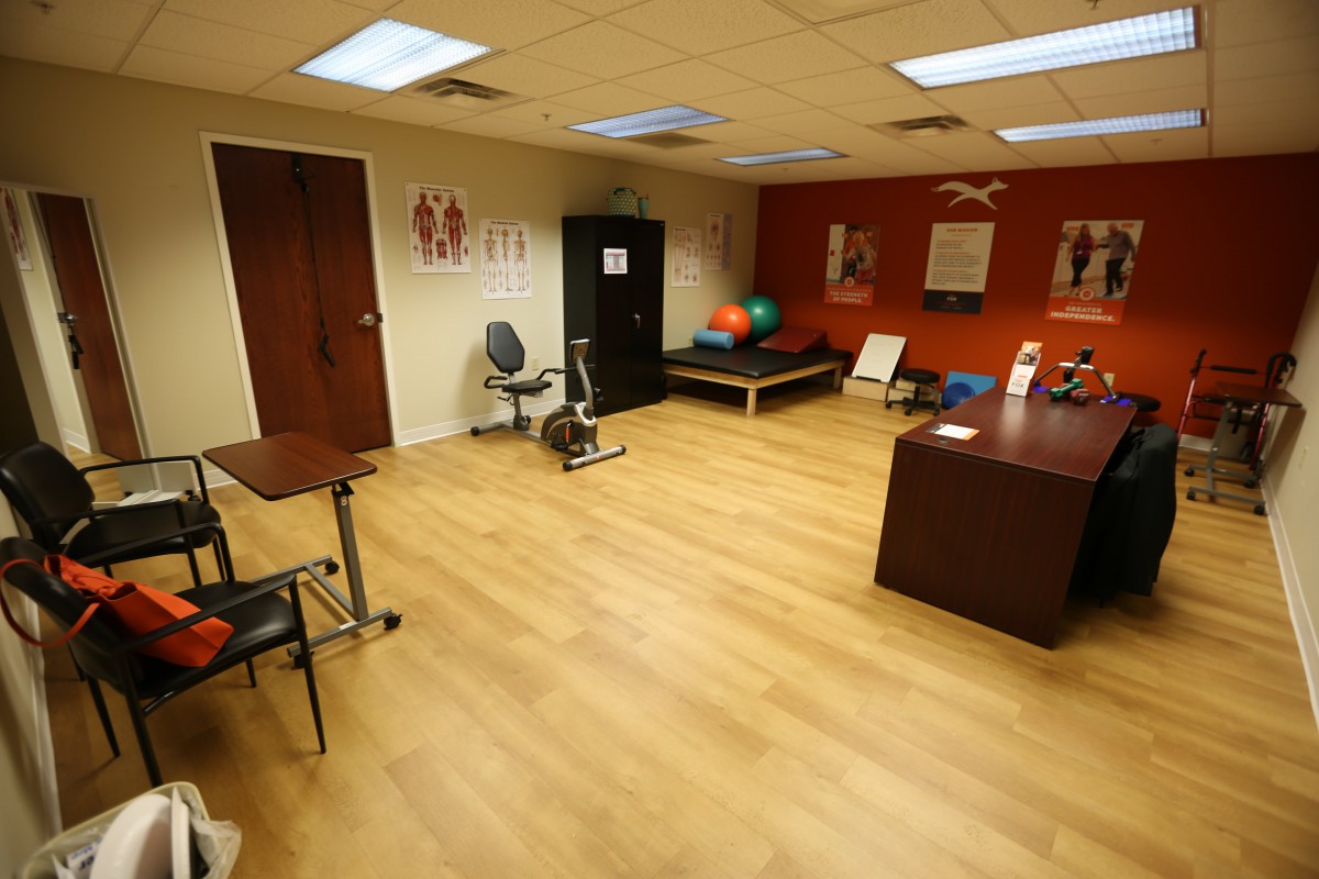A physical therapy room equipped with exercise equipment and a treatment table.