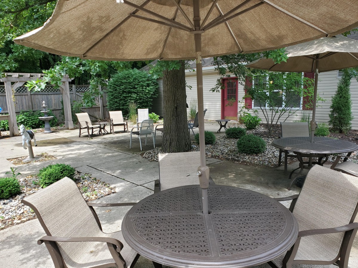 A cozy outdoor patio area with tables, chairs, and umbrellas set up for relaxation.