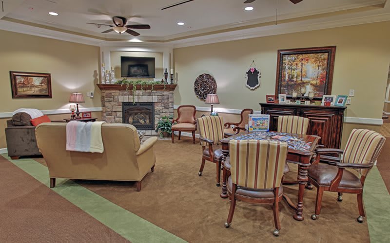 A cozy living room with a fireplace and a seating area.
