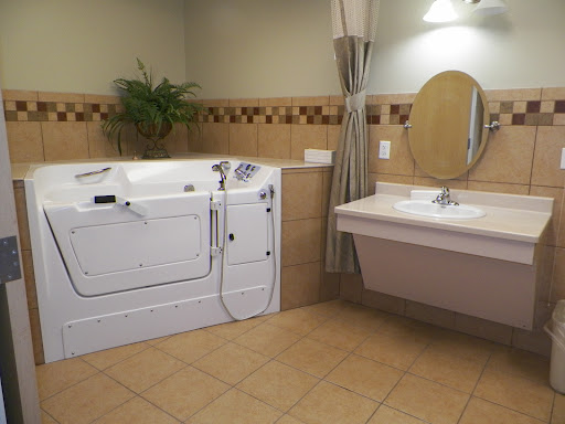 A modern bathroom featuring a jacuzzi tub alongside a sink and mirror.
