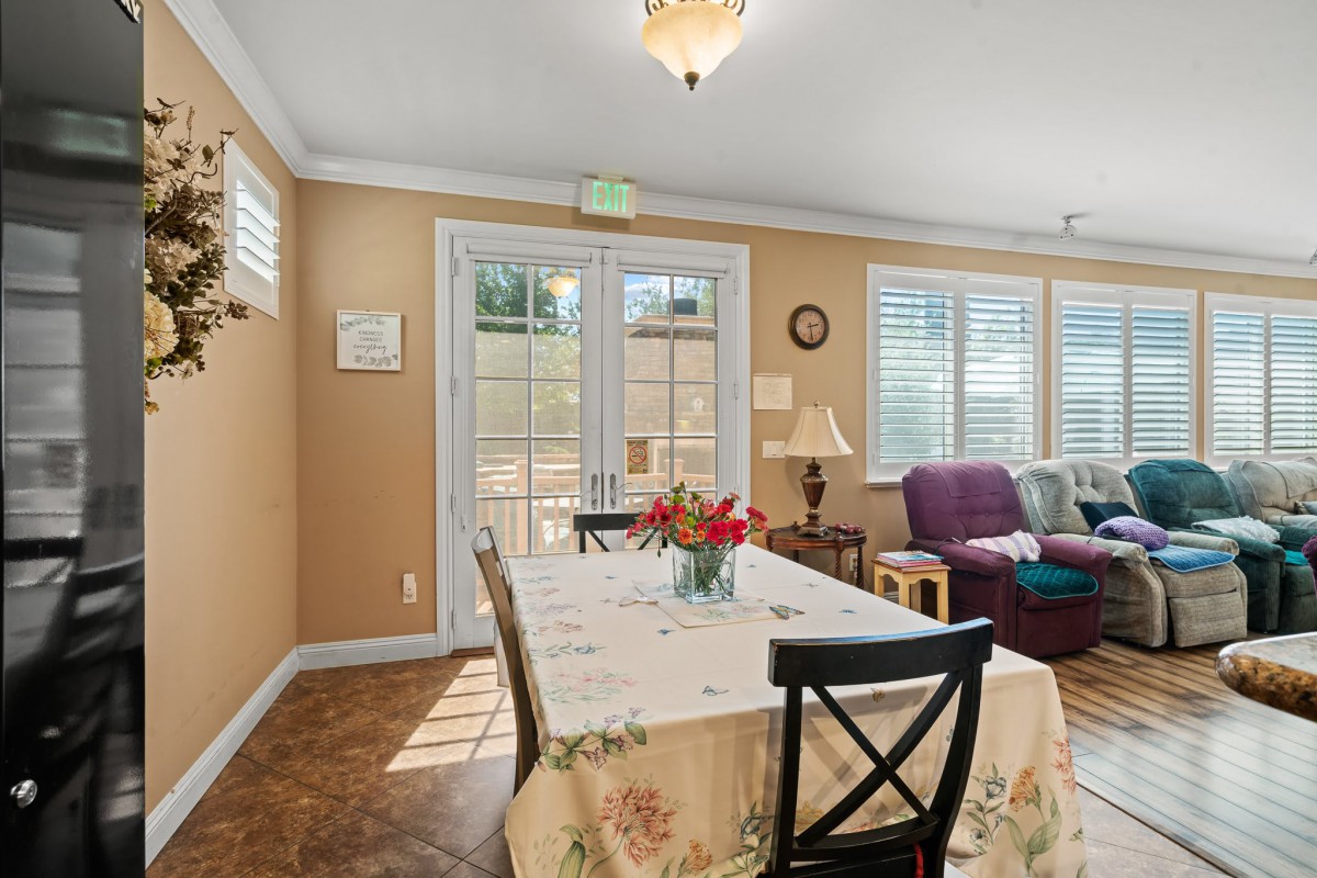 A cozy dining area with a table set for guests and a comfortable seating arrangement by the windows.