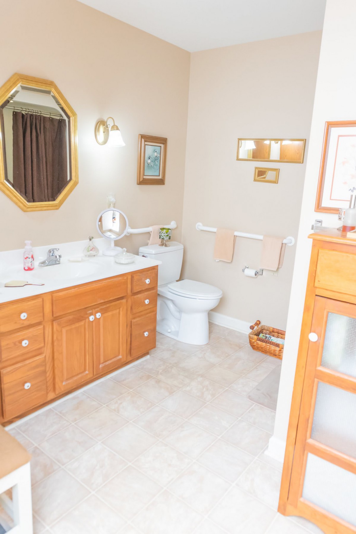 A clean and well-organized bathroom with a wooden vanity, mirror, and toilet.