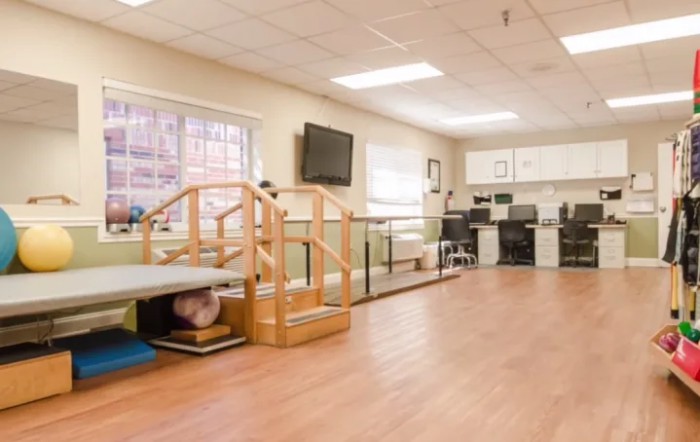 A spacious rehabilitation and therapy room equipped with various exercise equipment.