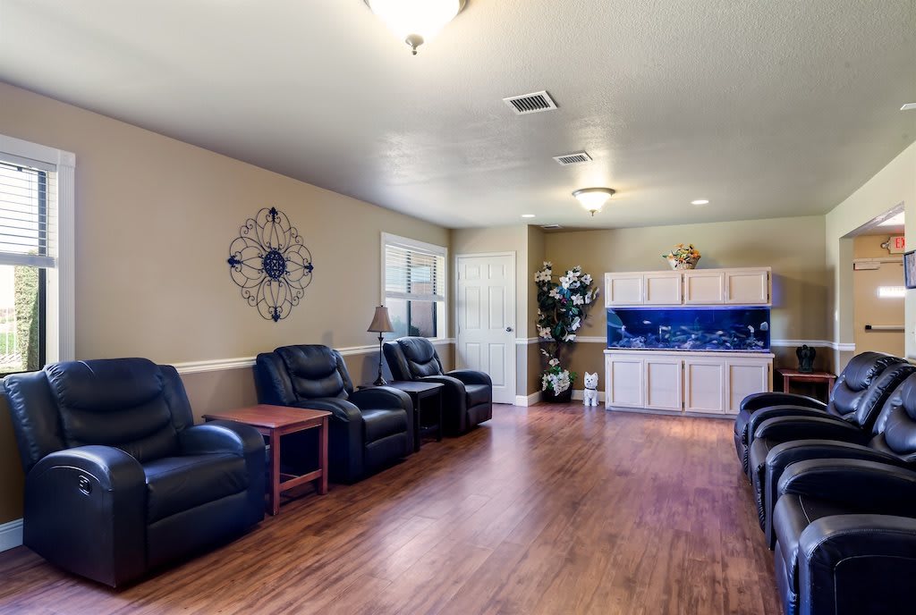 A spacious living room with leather chairs and hardwood flooring.