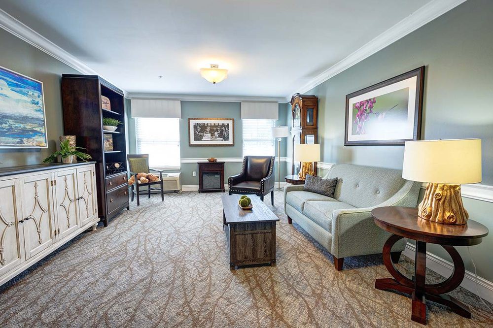 A cozy living room featuring a sofa, coffee table, and bookshelf with stylish decor.