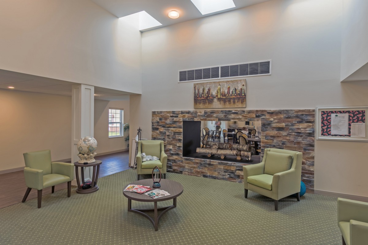 A modern living room with a stone fireplace, skylights, and comfortable seating.