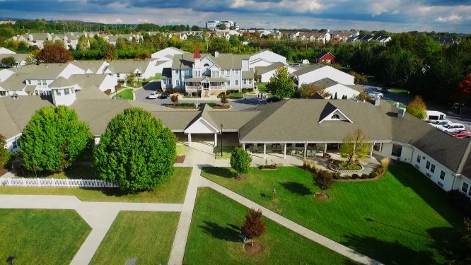 Aerial view of a suburban residential area with green spaces and cloudy skies.