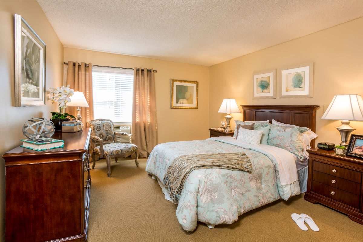A cozy bedroom with a well-made bed, stylish furniture, and warm lighting.