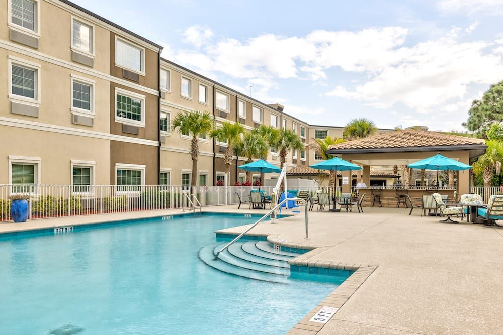 A luxurious hotel pool area with seating and umbrellas, perfect for relaxation.