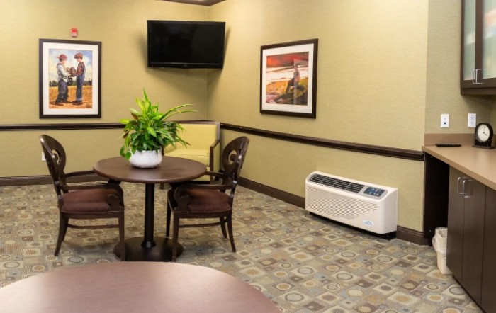 A cozy room with a table and chairs, wall-mounted TV, and decorative elements.