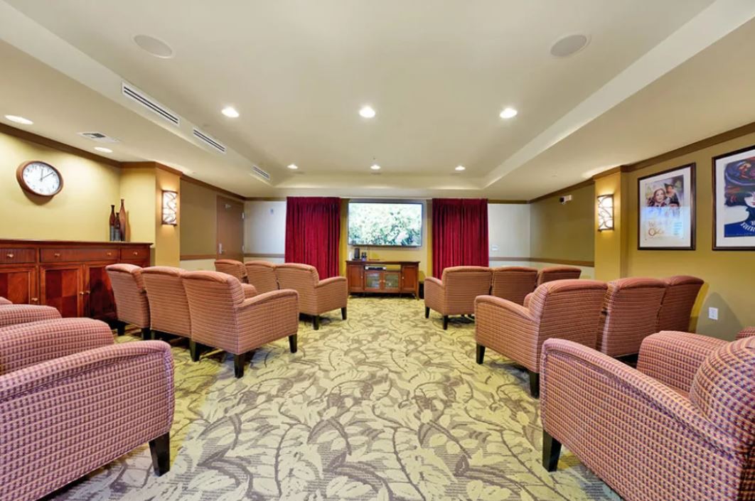 A cozy home theater room with comfortable seating and a large screen.