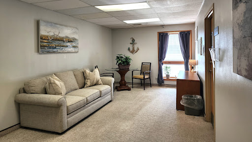A cozy office lounge space featuring a comfortable sofa, a desk, and decorative elements.