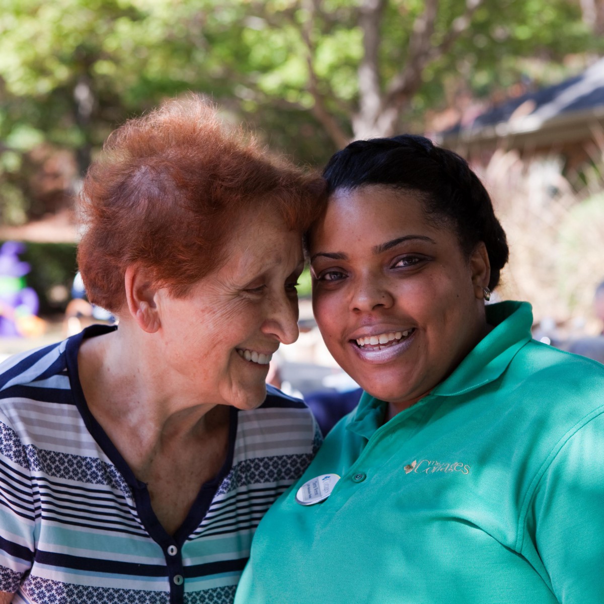 Two people smiling together outdoors.