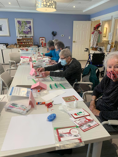 Seniors engaged in a creative crafting session at a community center, enjoying art and company.