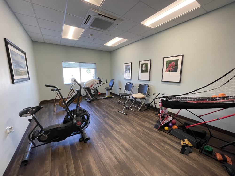 A small exercise room with various fitness equipment, including a stationary bike and treadmill.