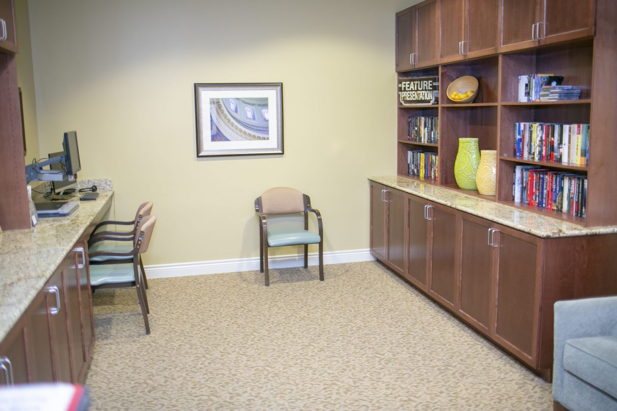 A waiting room with chairs, a cabinet, and decorative items.