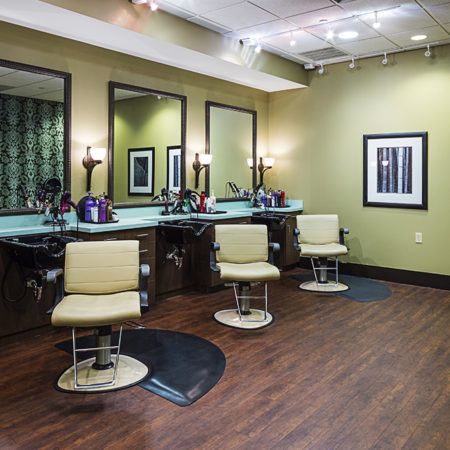 A modern barbershop interior with styling chairs and mirrors.